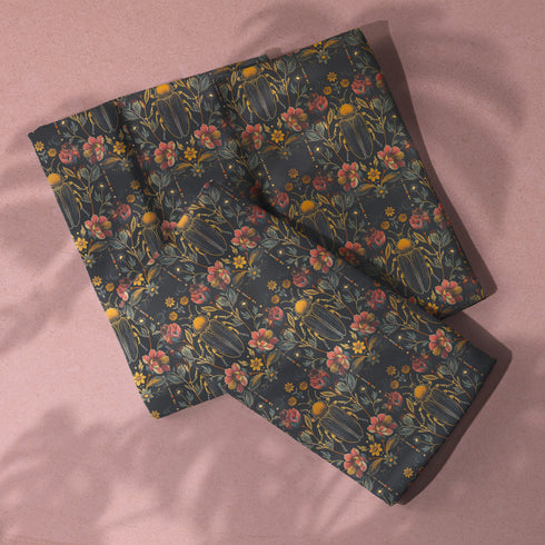 Set of four dark green cloth napkins with a repeating pattern of golden beetles, coral flowers, and ochre wildflowers in an intricate botanical and entomological design.